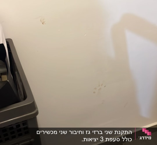 קיר לבן עם סימני לכלוך, סלסלה אפורה בצד
